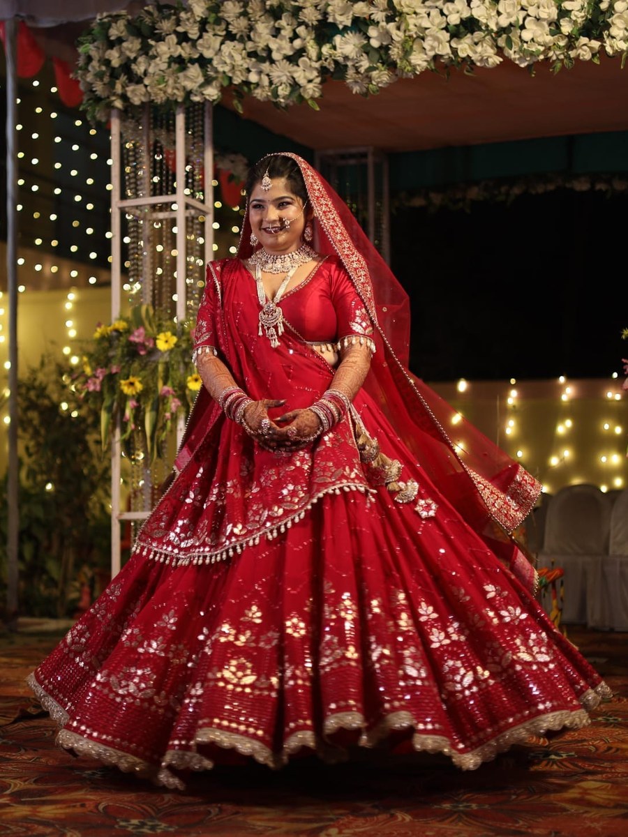 Bride twirling in red bridal lehenga by Hello Beautiful Boutique