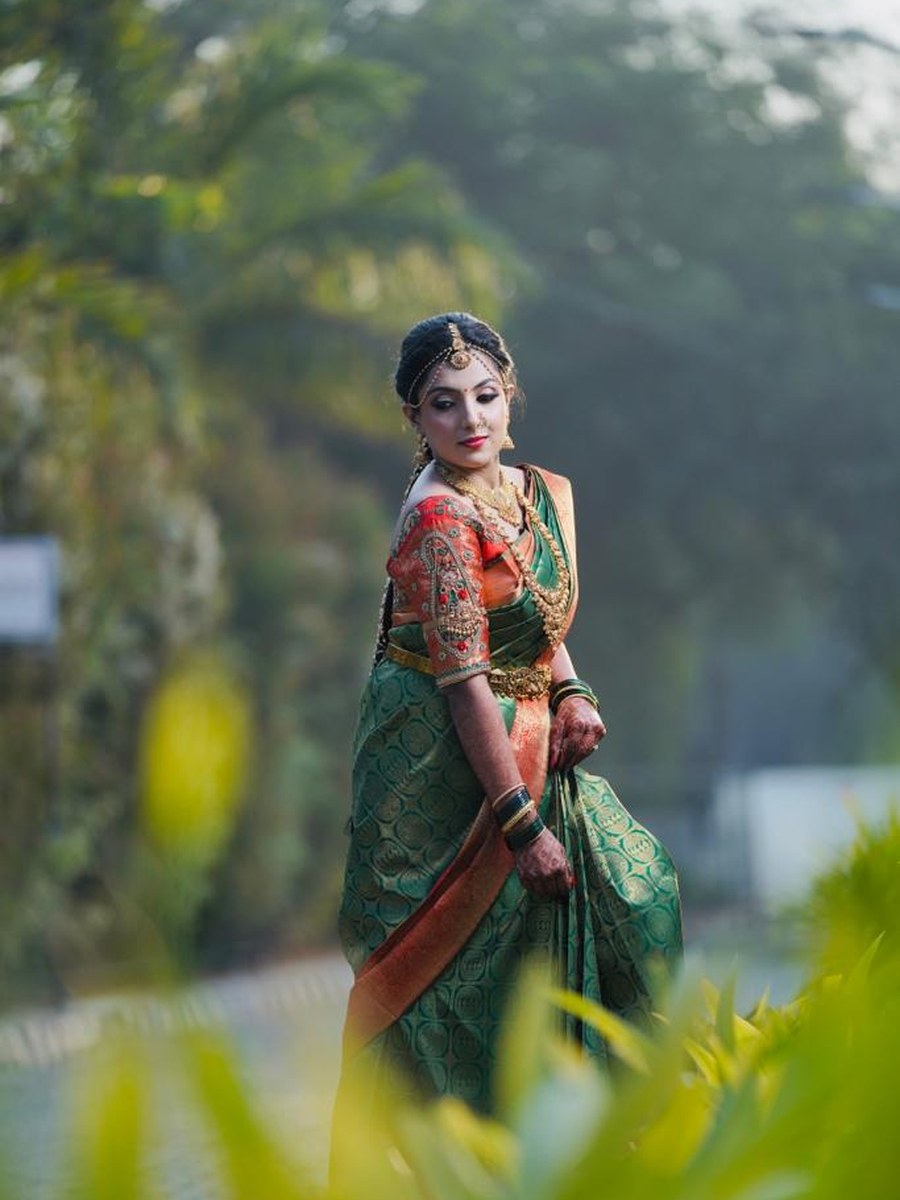 Bride in green and orange silk saree blouse by Hello Beautiful Boutique
