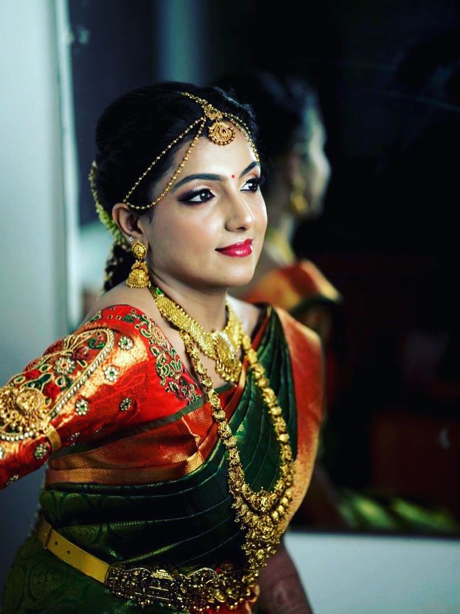 Close portrait of bride in green and red silk saree blouse by Hello Beautiful Boutique