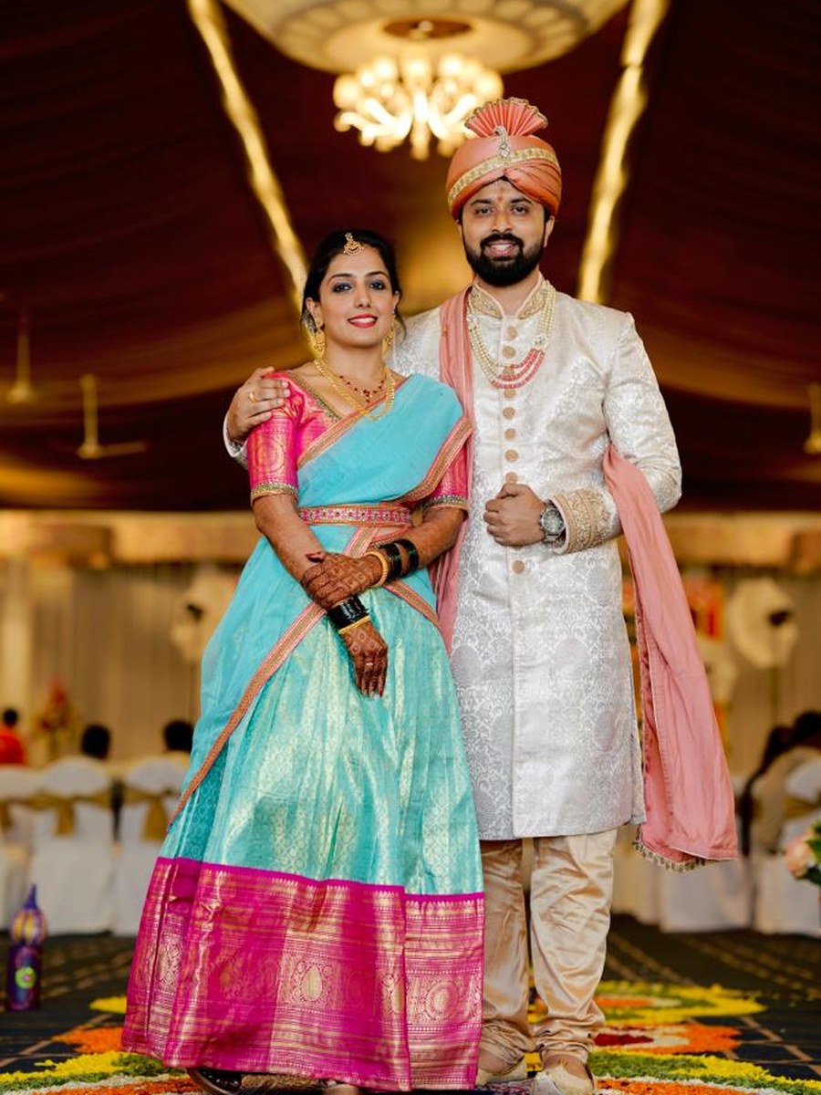 Couple in turquoise-pink silk saree and cream sherwani by Hello Beautiful Boutique