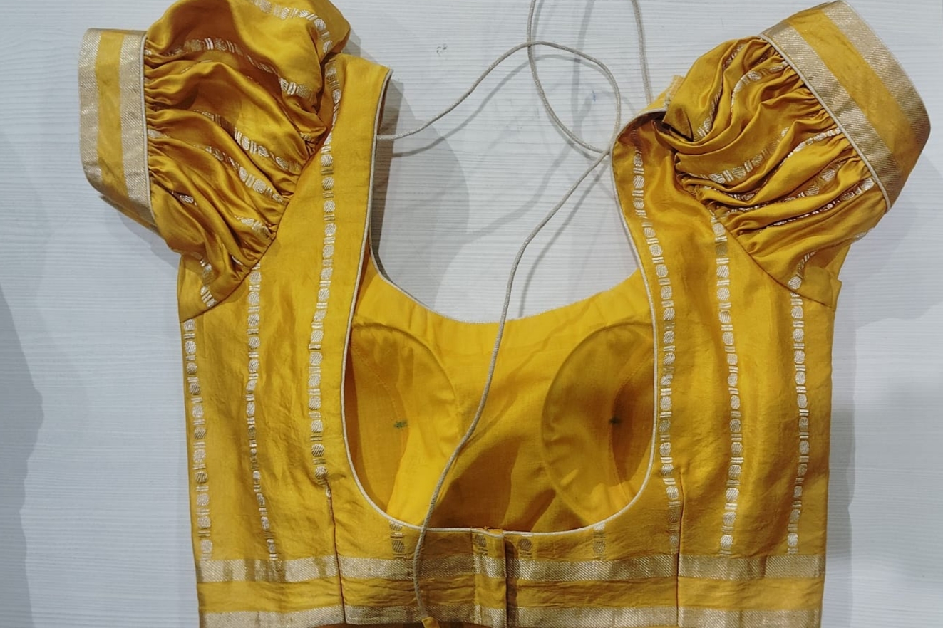 Mustard yellow blouse with gold zari border and puff sleeves
