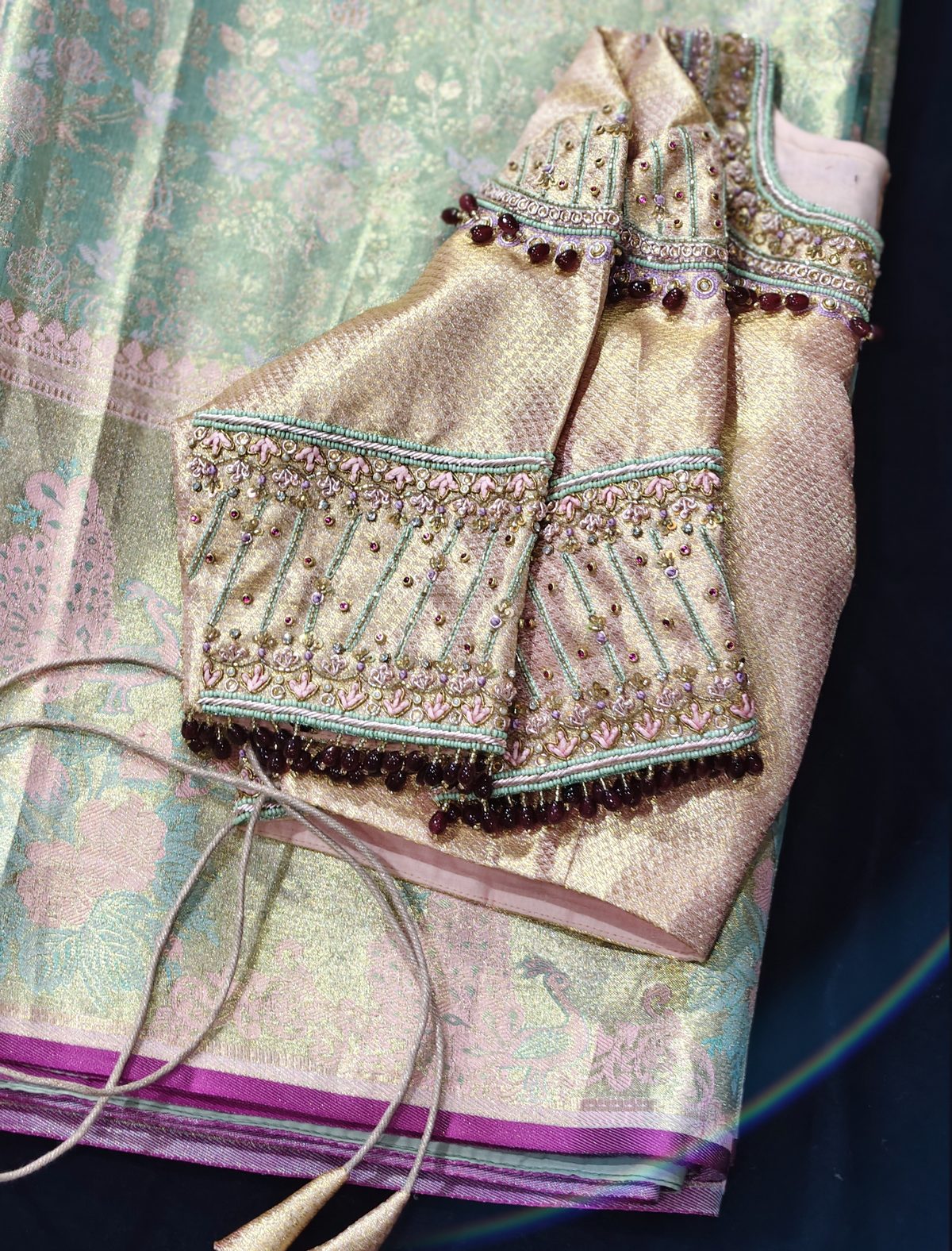 Beaded gold blouse sleeves styled alongside a mint green Banarasi saree